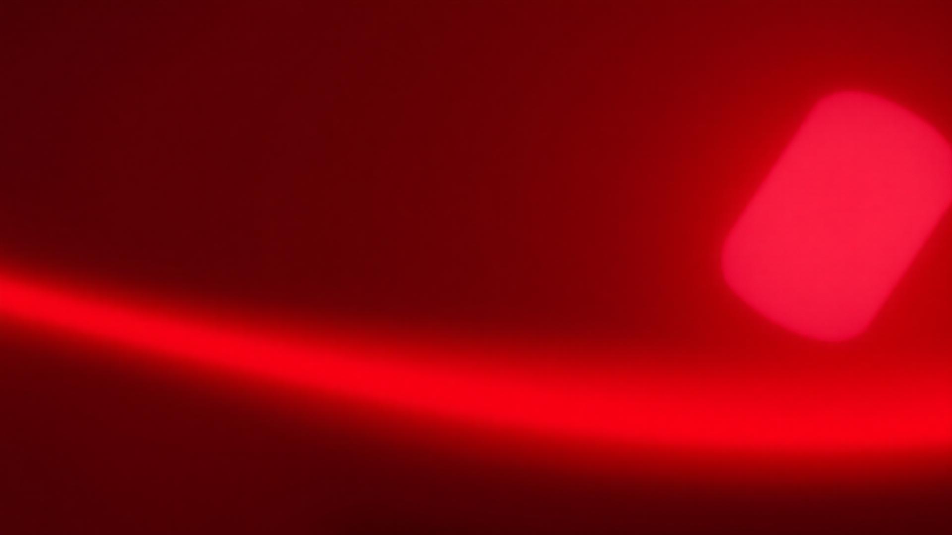 Close-up of deep metallic red automotive paint reflecting booth lighting