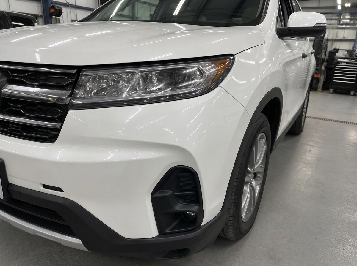 The same white SUV front bumper and fender restored and repainted after repair