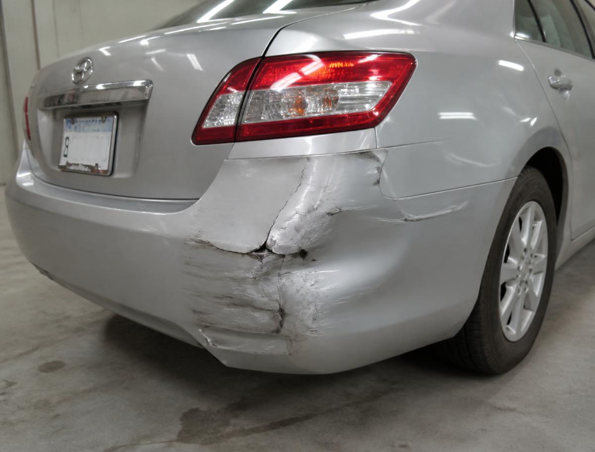 Silver sedan rear bumper corner gouged, cracked and dented before bumper repair